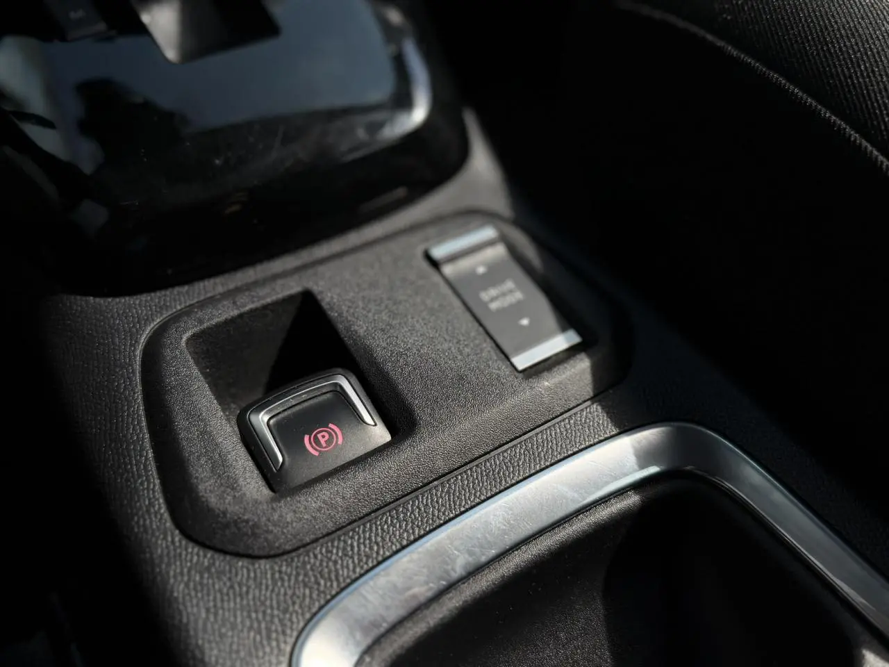 Gros plan sur la commande de frein de parking électrique et démarrage moteur dans l’habitacle de l’Opel Corsa 2025.