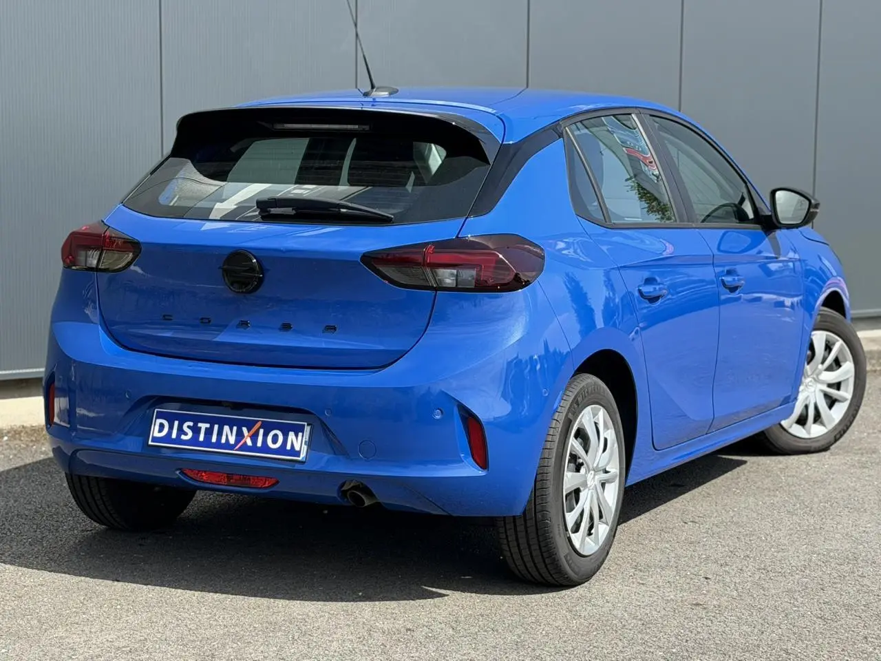 Vue 3/4 arrière droite d'une Opel Corsa bleu Voltaic avec feux arrière LED et jantes alliage.