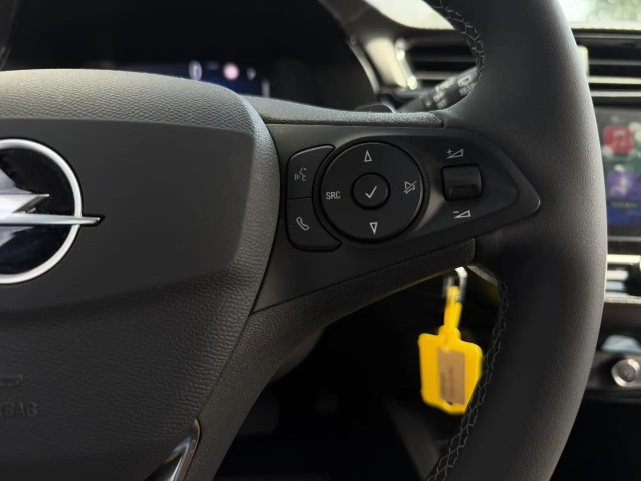 Gros plan sur le volant multifonction noir de l’Opel Corsa 2025 avec commandes intégrées et logo Opel visible.