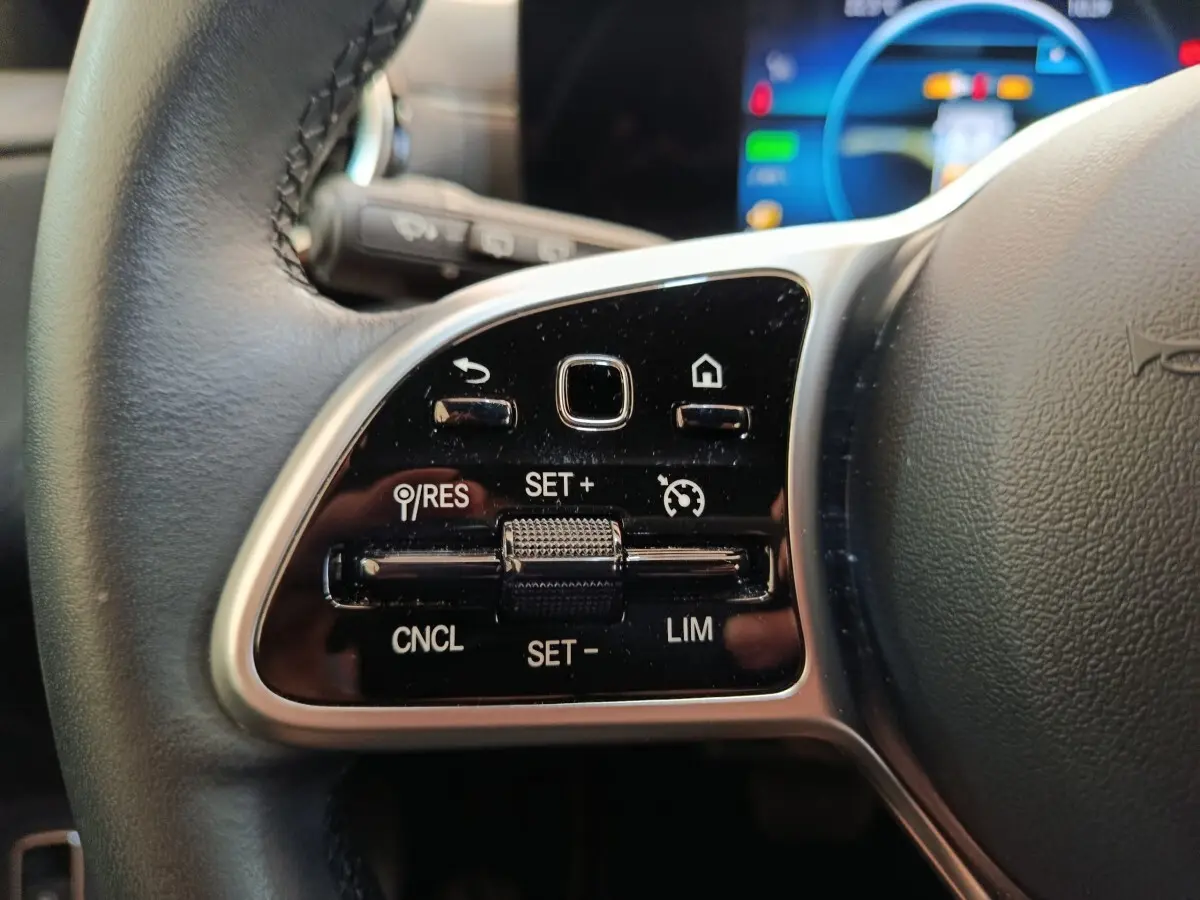 Gros plan sur le volant cuir noir de la Mercedes Classe A 250 e Business Line 2022, avec commandes multifonctions visibles.