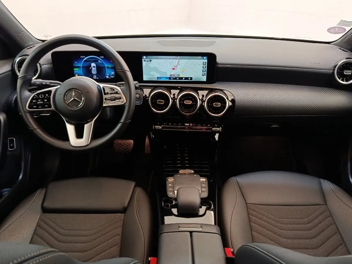 Vue intérieure avant de la Mercedes Classe A 250 e Business Line noire, avec tableau de bord numérique et écran tactile central.