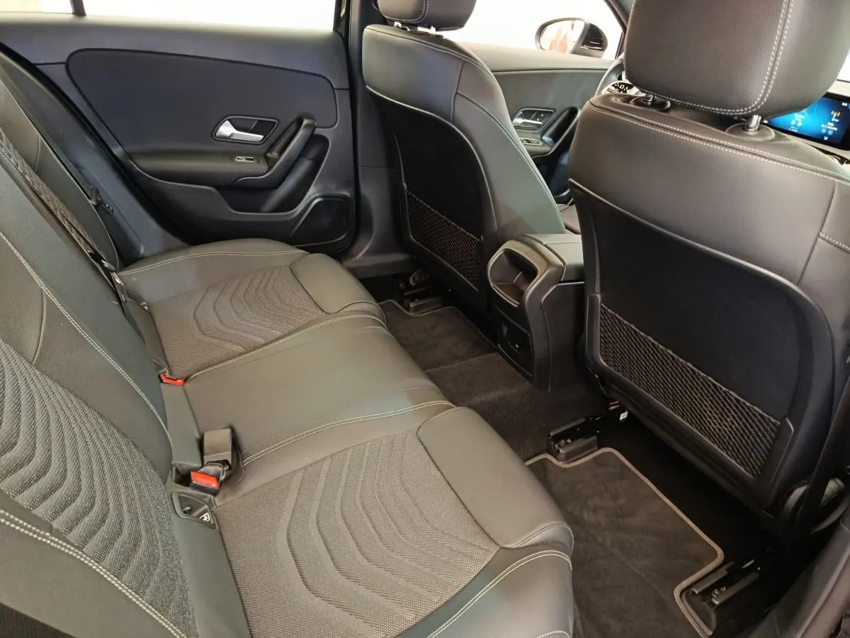 Vue intérieure arrière côté droit de la Mercedes Classe A 250 e Business Line 2022 avec sièges en cuir noir et tissu.