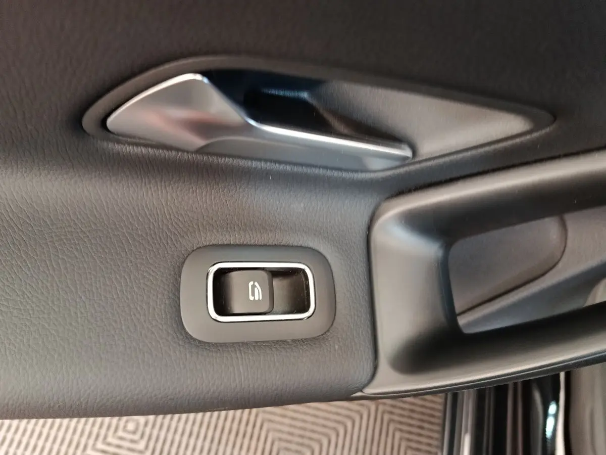 Gros plan sur la commande de verrouillage de porte noire et chrome côté conducteur d'une Mercedes Classe A 250 e Business Line 2022.