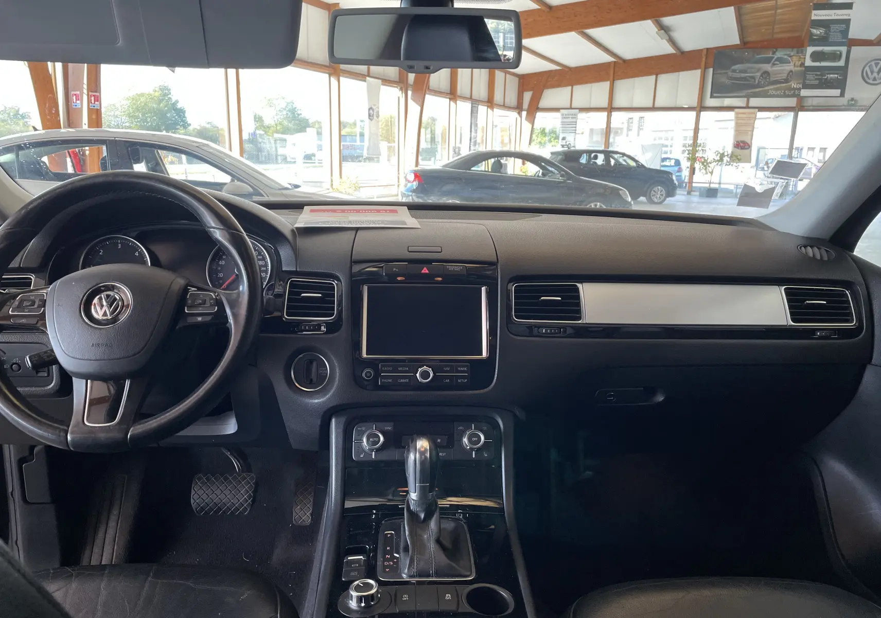 Vue intérieure du tableau de bord noir du Volkswagen Touareg 2012, avec volant multifonction et console centrale moderne.