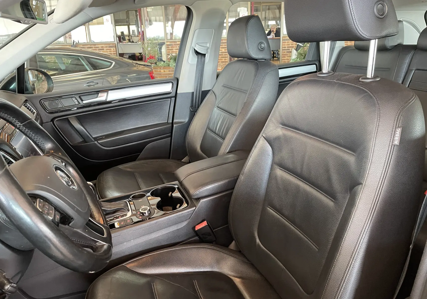 Intérieur noir en cuir du Volkswagen Touareg 2012 vu côté conducteur avec console centrale et volant multifonction.