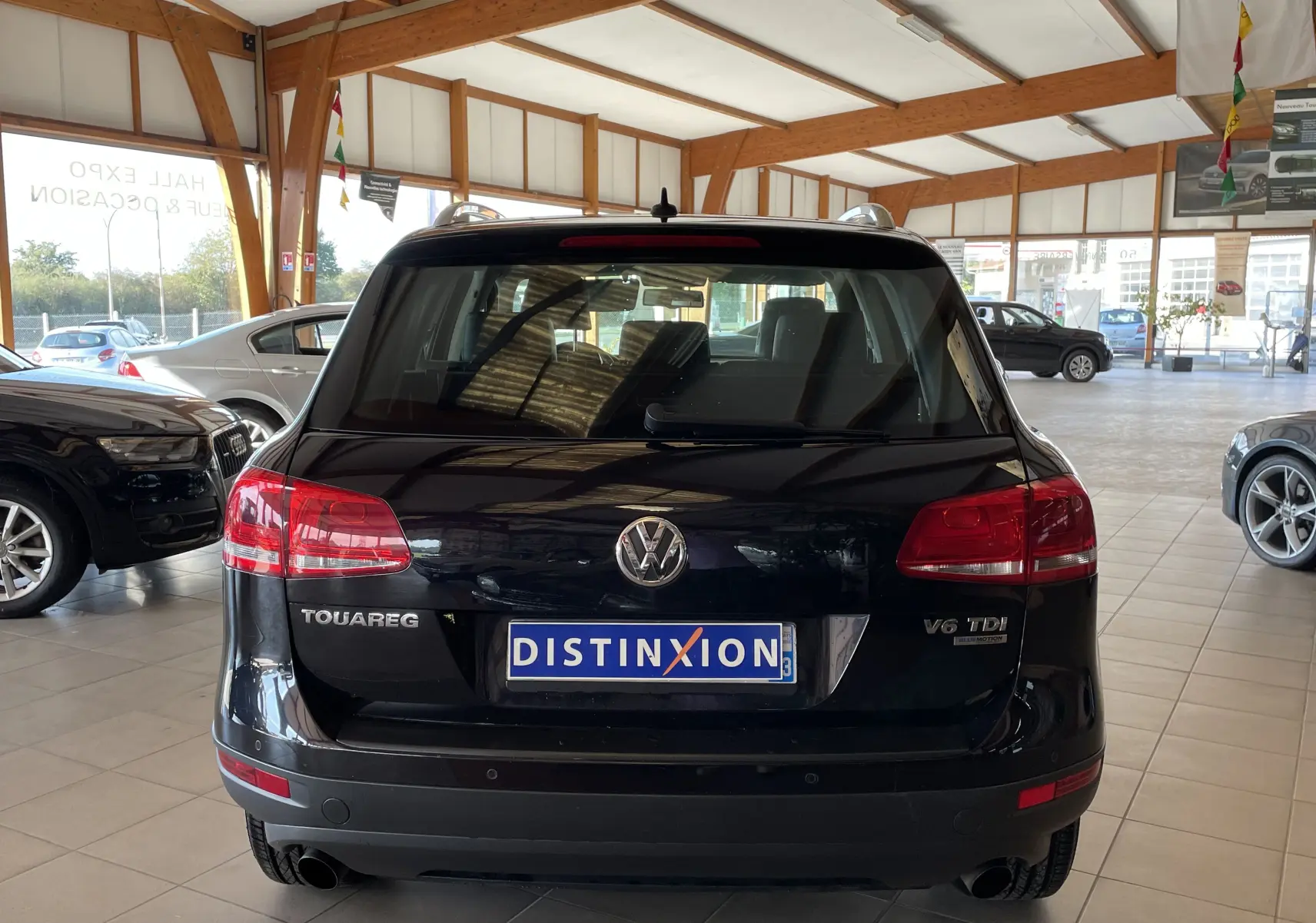 Vue arrière d'un Volkswagen Touareg noir 2012 avec badges V6 TDI et 4Motion en showroom lumineux.