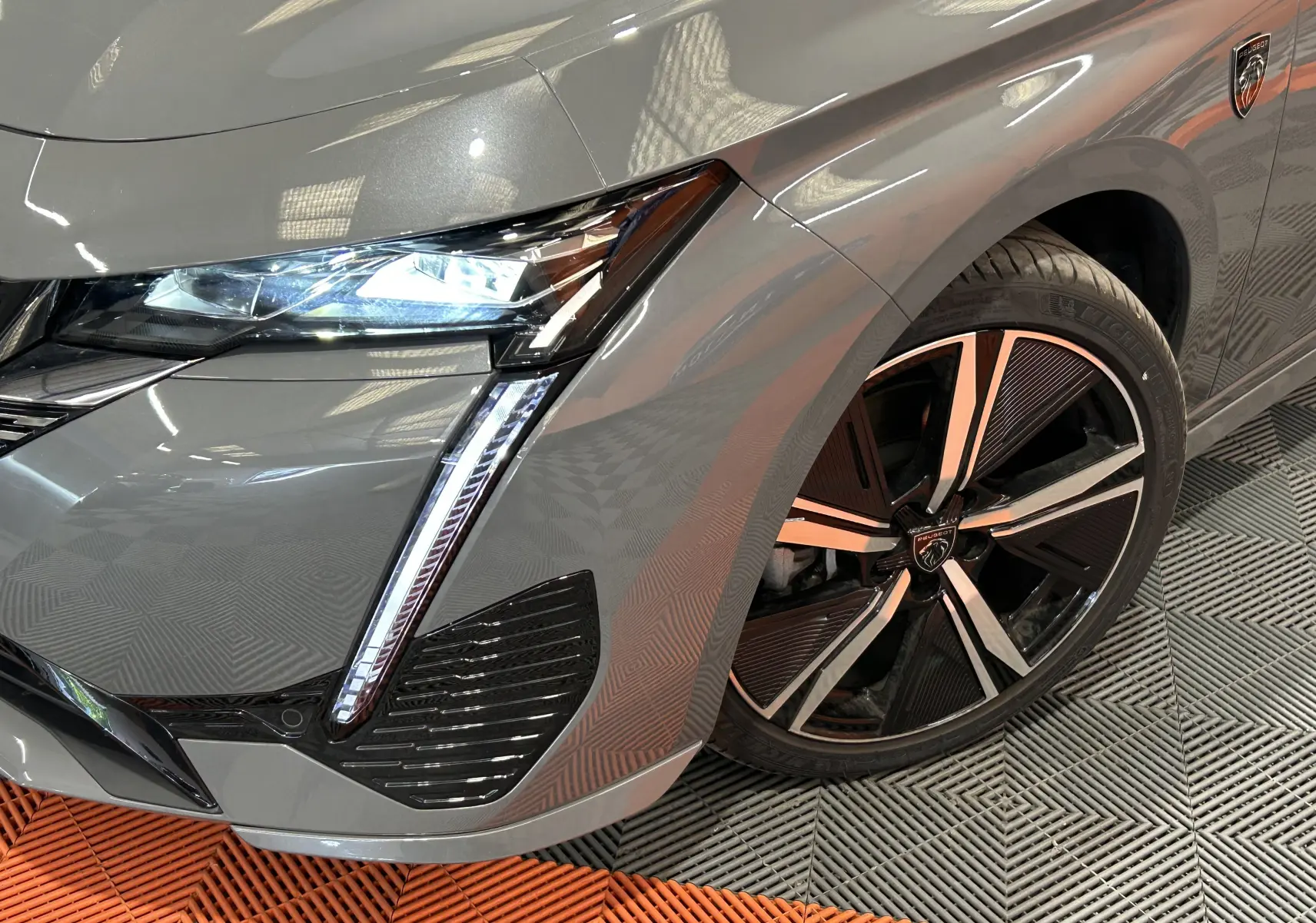 Gros plan sur l'avant droit gris Sellenium du Peugeot 308 SW III GT avec phares LED et jante alliage distinctive.
