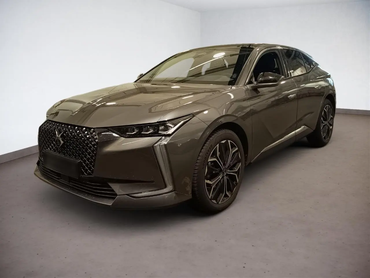 DS4 2025 gris Platinium en 3/4 avant droit avec calandre distinctive et jantes alliage 19 pouces.