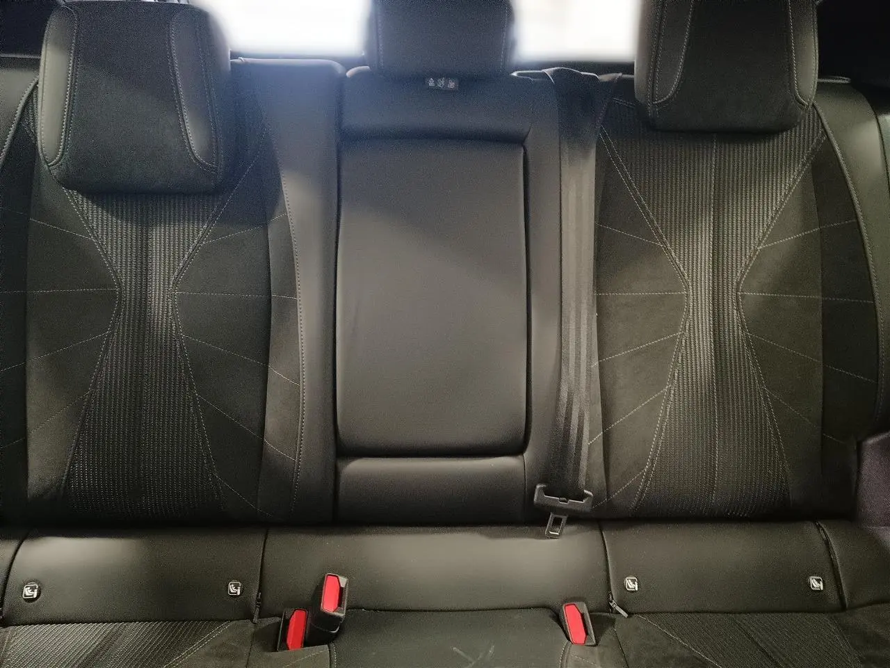 Banquette arrière en tissu tressé noir avec alcantara du DS4 2025, montrant les appuie-têtes et ceinture de sécurité.