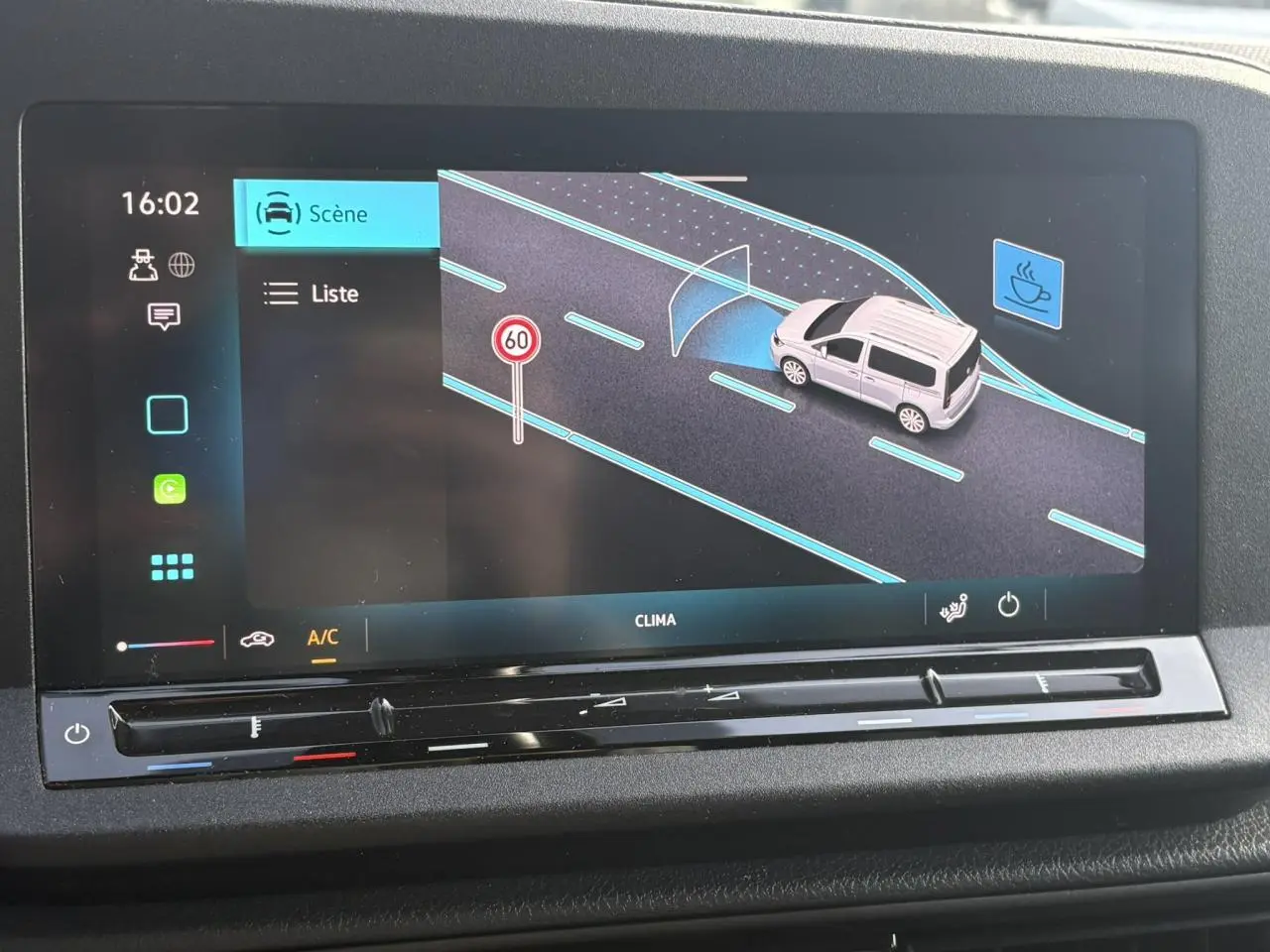 Écran tactile intérieur montrant l'assistance Front Assistant avec un Volkswagen Caddy gris Pure Grey sur route.