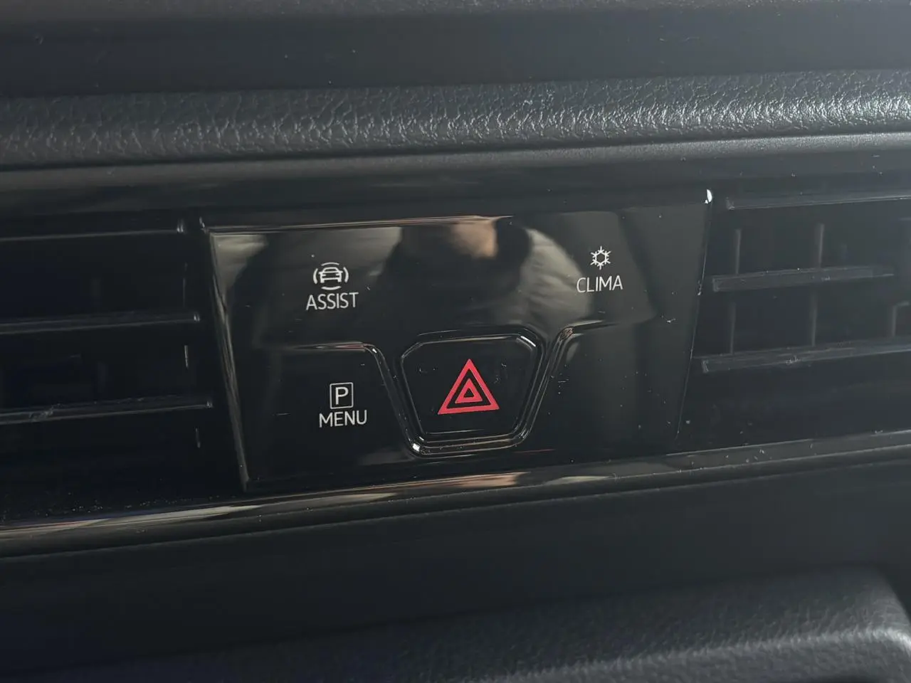 Gros plan sur les commandes d'assistance et de climatisation du tableau de bord du Volkswagen Caddy 2024 gris Pure Grey.