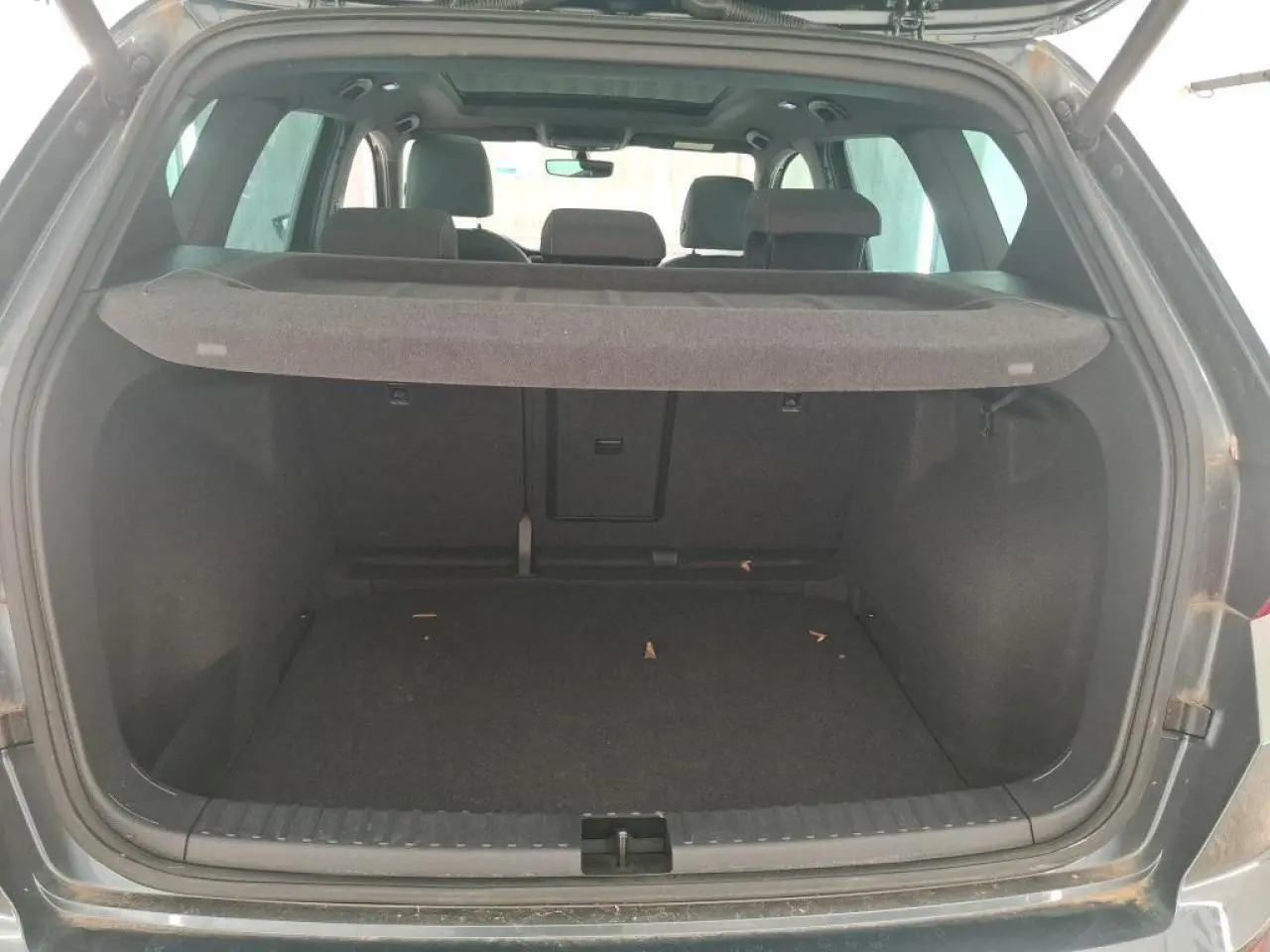 Coffre ouvert vu de l’arrière d’un SEAT Ateca gris clair avec cache-bagages en place.