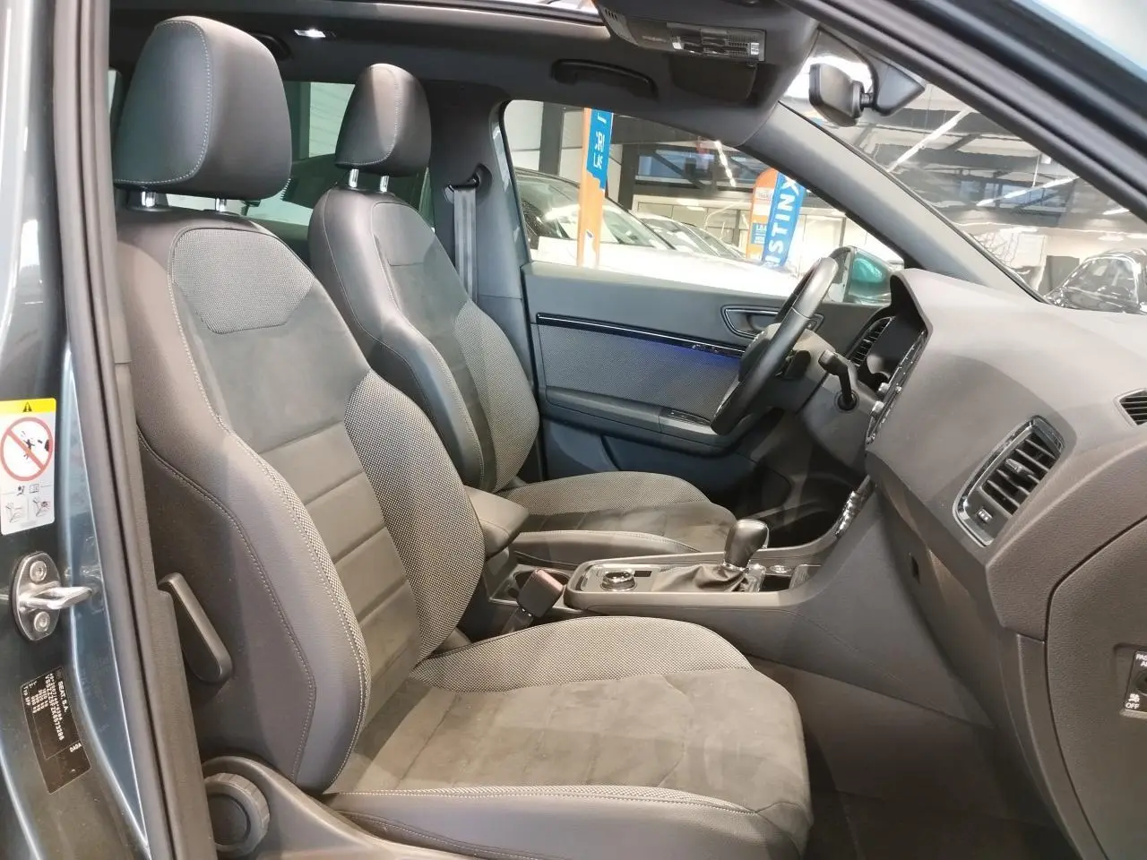 Vue intérieure côté conducteur du SEAT Ateca gris clair 2019, montrant sièges avant en alcantara et console centrale.