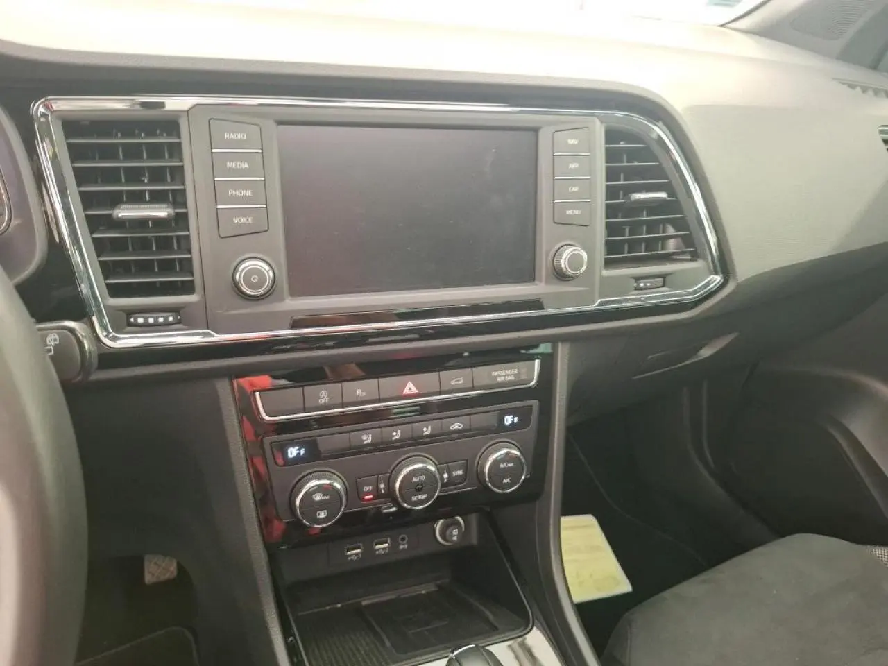 Vue intérieure du tableau de bord du SEAT Ateca gris clair, avec écran tactile et commandes de climatisation visibles.