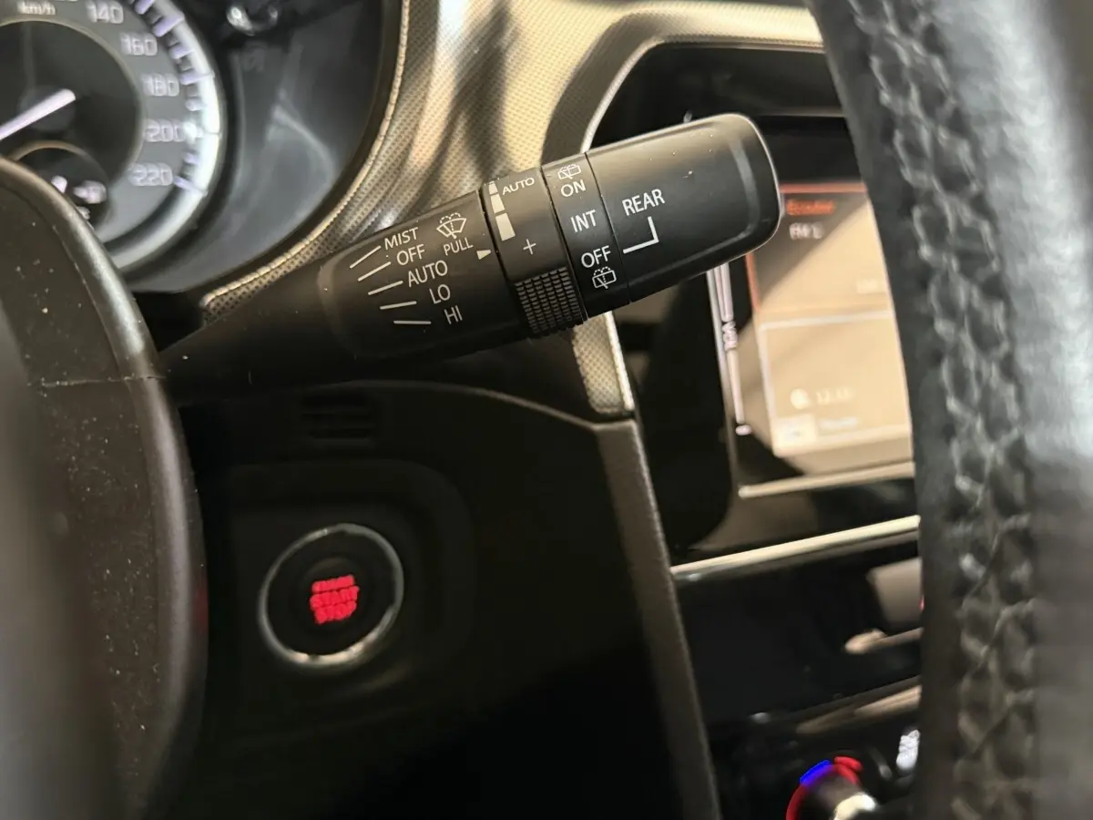 Gros plan sur la commande d’essuie-glace et bouton démarrage rouge du tableau de bord noir du Suzuki Vitara 1.5 Hybrid.
