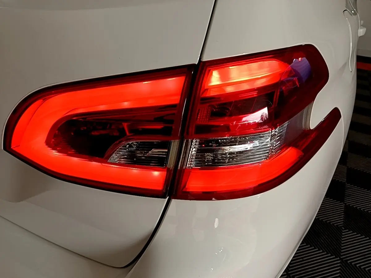 Gros plan sur le feu arrière droit rouge d’une Peugeot 308 blanche, soulignant la finition moderne et les lignes épurées.