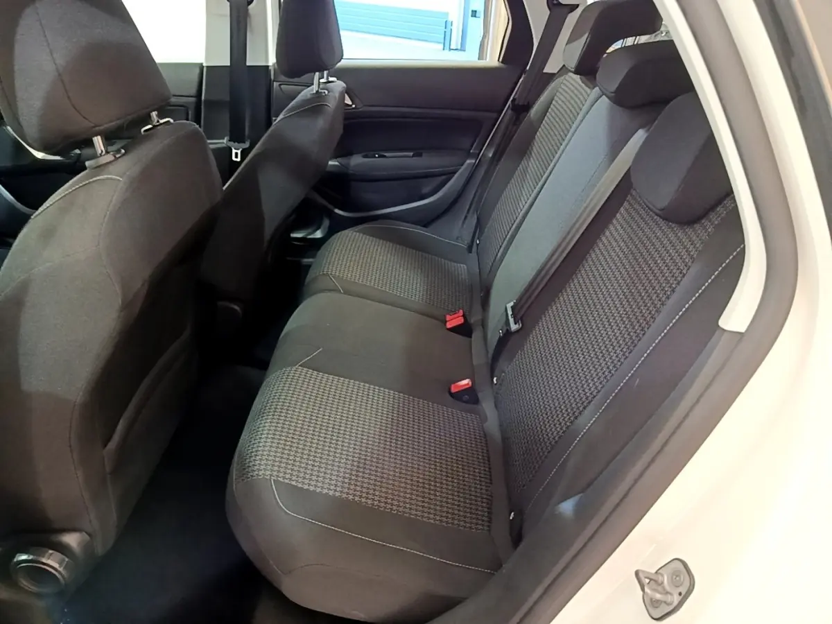 Vue intérieure côté droit sur la banquette arrière noire à motifs de la Peugeot 308 blanche, porte ouverte.