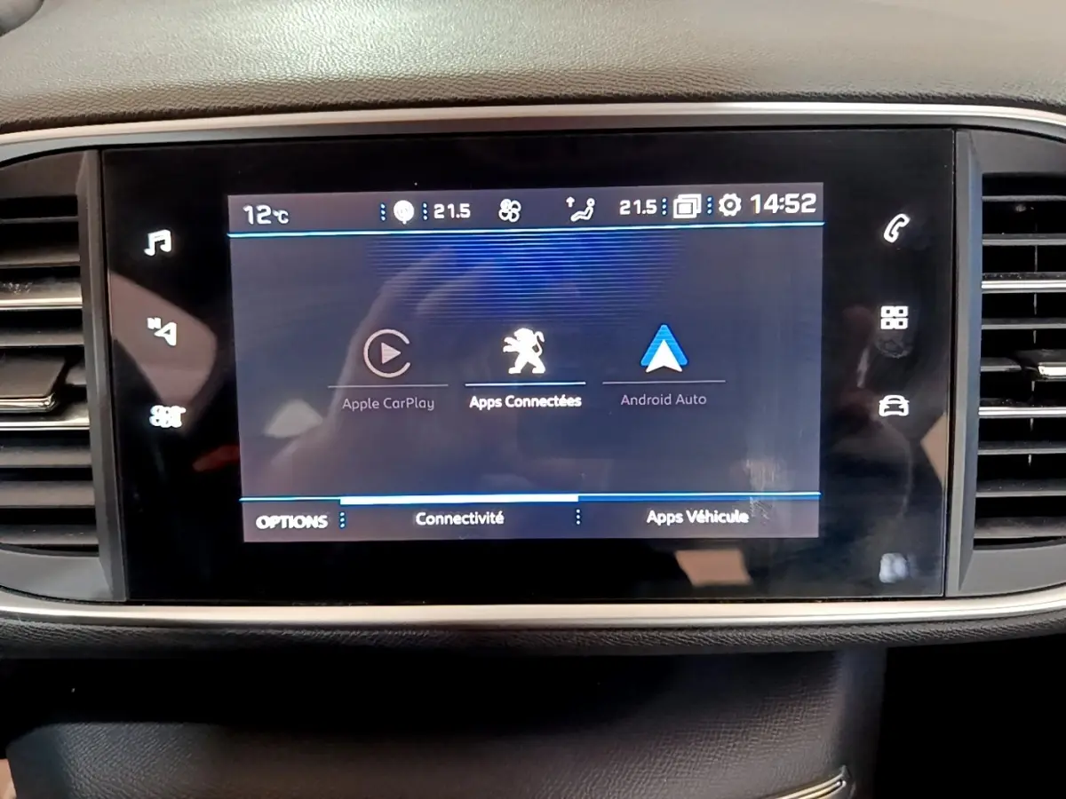 Écran tactile central affichant Apple CarPlay et Android Auto dans l’habitacle d’une Peugeot 308 blanche.