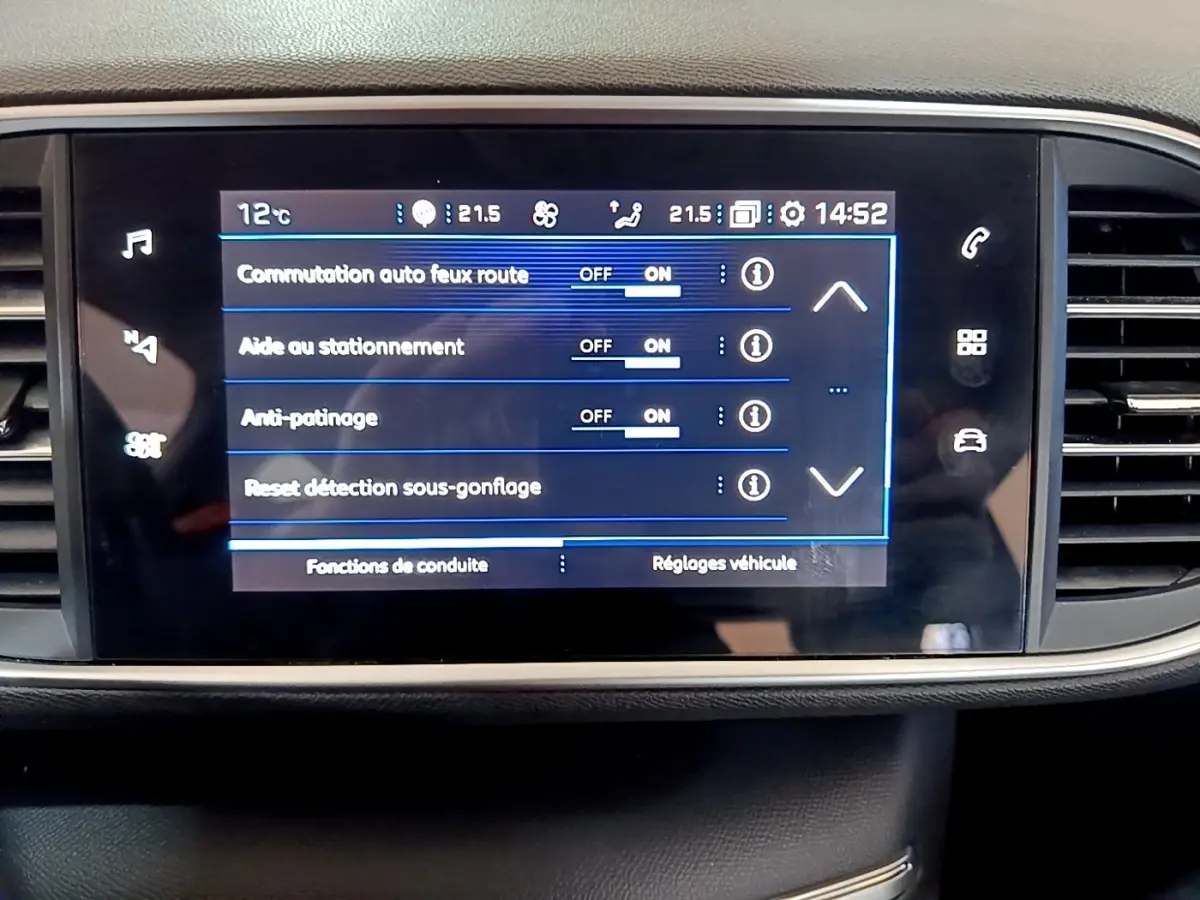 Écran tactile central du tableau de bord de la Peugeot 308 blanc, affichant les réglages d’aide à la conduite.