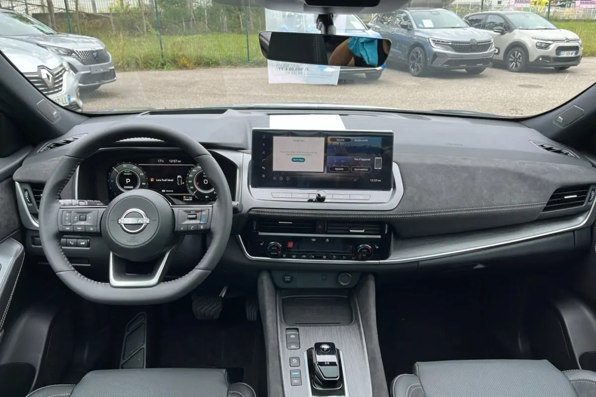 Vue intérieure frontale du tableau de bord du Nissan Qashqai E-POWER 205 Tekna Plus avec écran tactile et volant multifonctions.