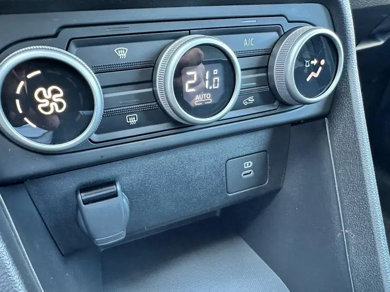 Gros plan sur les commandes de climatisation automatique de la Dacia Sandero 2025, avec affichage digital à 21°C.