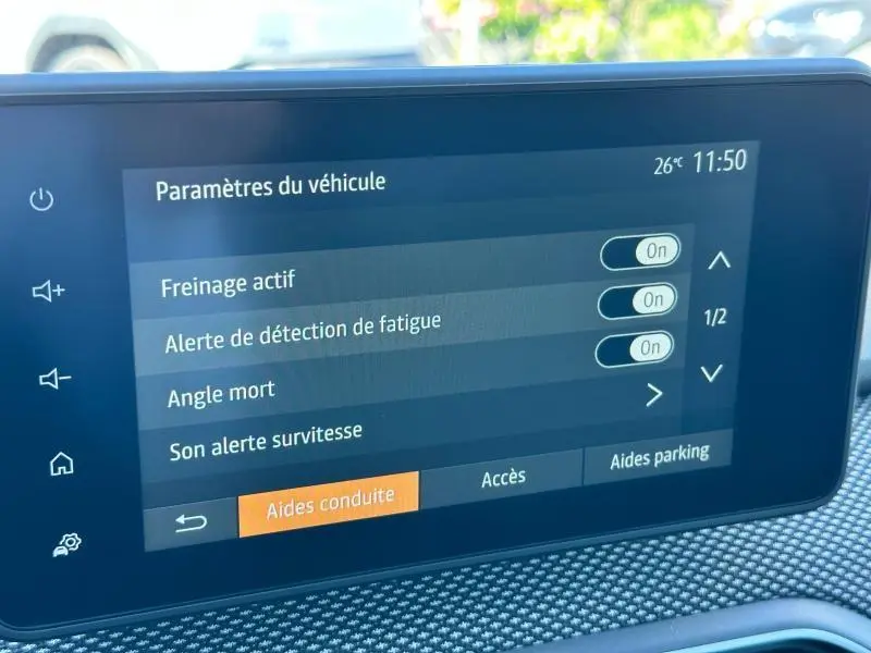 Écran tactile central de la Dacia Sandero 2025 affichant les paramètres d’aides à la conduite, intérieur gris texturé.