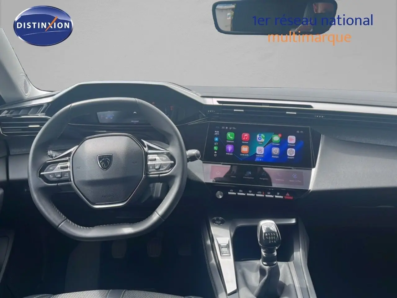 Vue intérieure du poste de conduite de la Peugeot 308 2024, tableau de bord moderne avec écran tactile et levier de vitesse manuel.