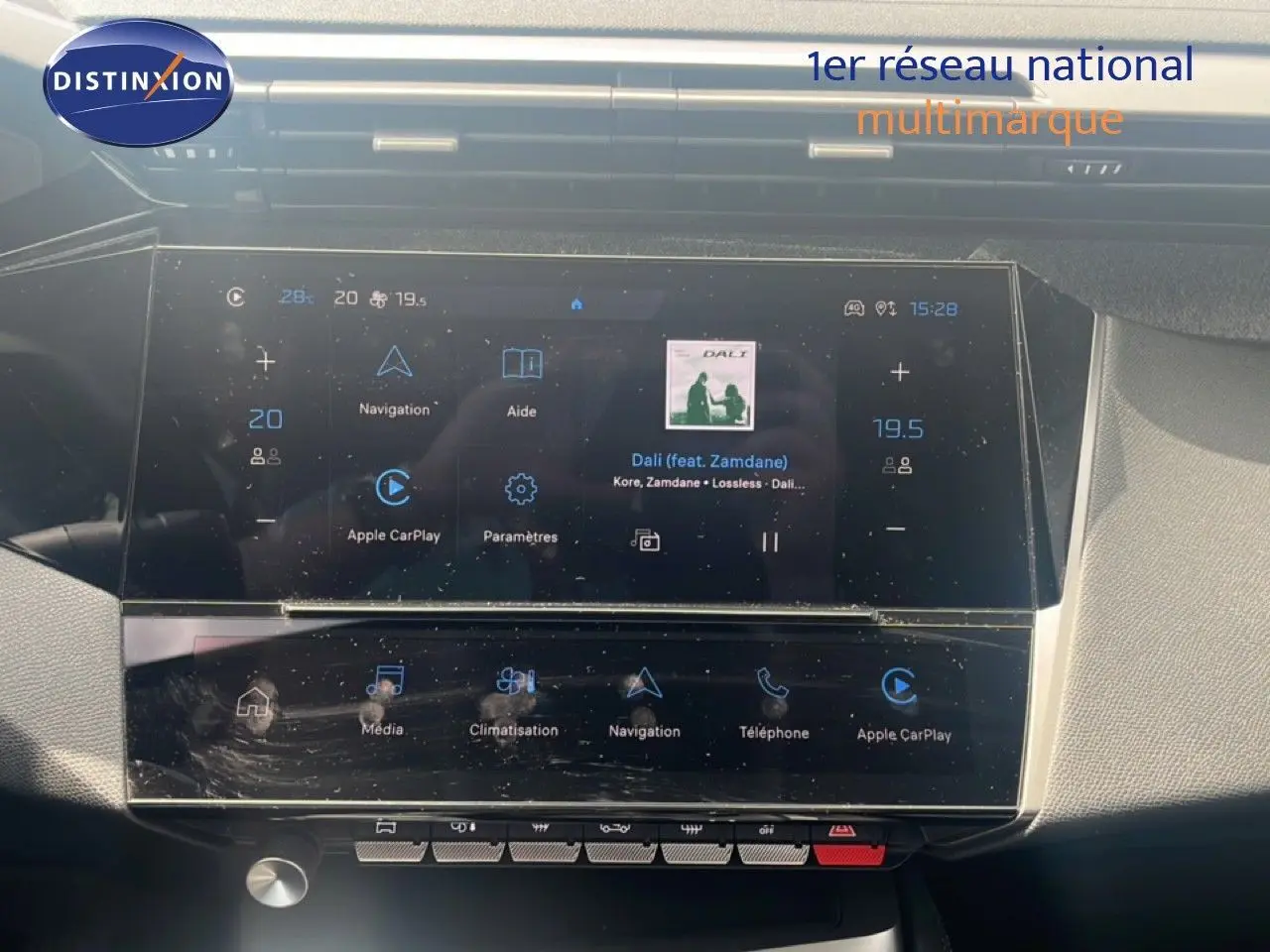 Écran tactile central de la Peugeot 308 2024 en vert olivine, affichant navigation et musique, vue intérieure frontale.