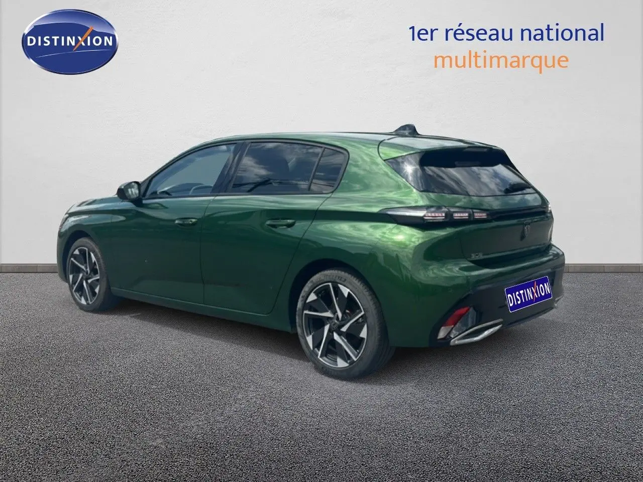 Vue 3/4 arrière droite d'une Peugeot 308 2024 vert olivine métal avec jantes alliage et vitres teintées.