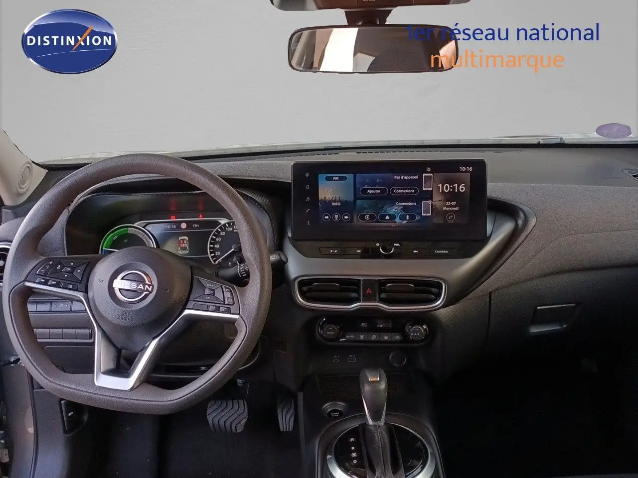 Vue intérieure du tableau de bord du Nissan Juke Hybrid 2025 avec écran tactile central et volant multifonction noir.