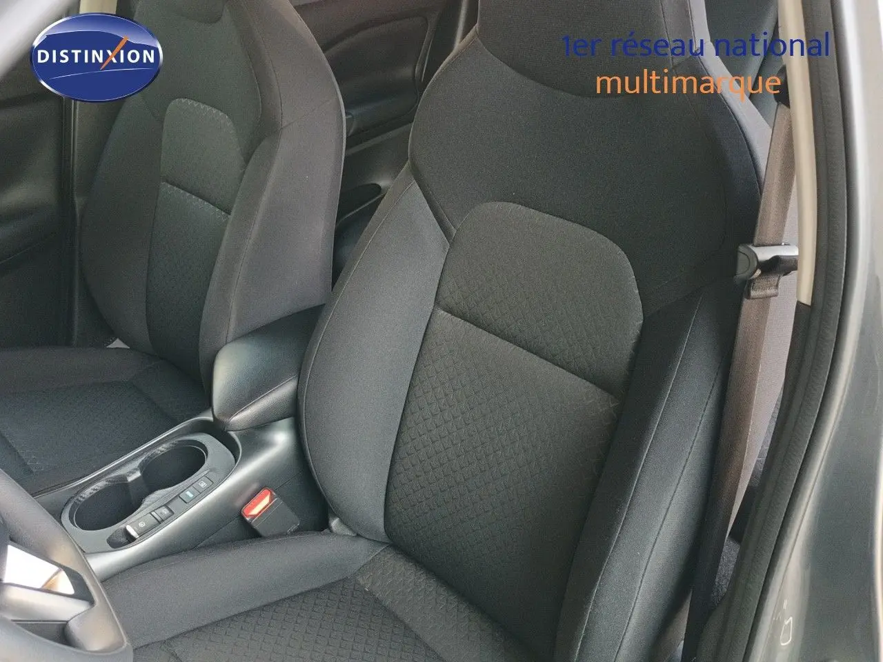 Vue intérieure rapprochée des sièges avant en tissu noir du Nissan Juke Hybrid 2025, côté conducteur ouvert.