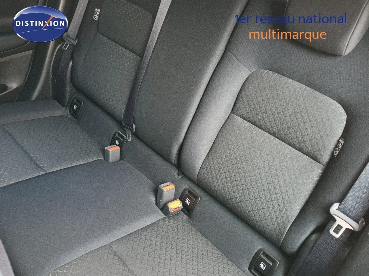 Vue rapprochée des sièges arrière en tissu gris foncé du Nissan Juke Hybrid 2025, montrant les ceintures et ancrages ISOFIX.