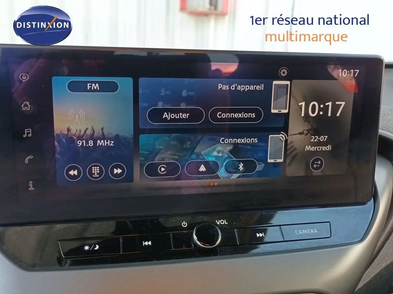 Écran tactile central du Nissan Juke Hybrid 2025, affichant radio FM et options de connexion, vue intérieure frontale.