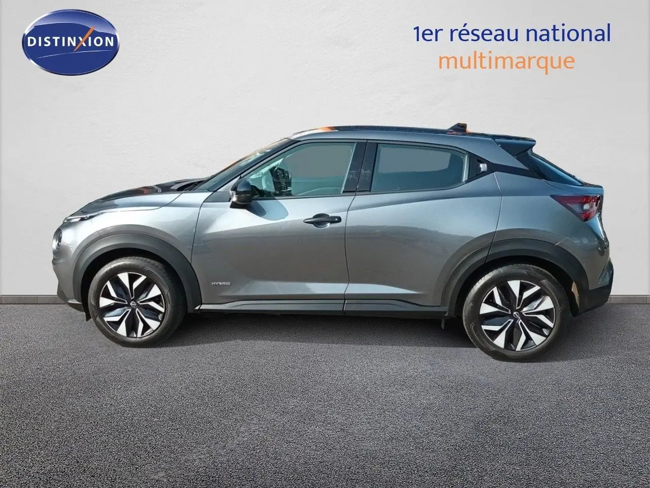 Profil droit du Nissan Juke Hybrid 143ch Acenta 2025 en gris squale métal avec jantes distinctives bicolores.