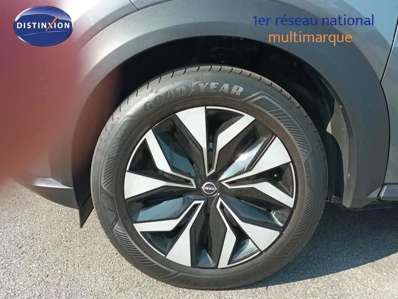 Gros plan sur la roue avant droite du Nissan Juke Hybrid 2025 en gris squale métal avec jante noire et argentée.
