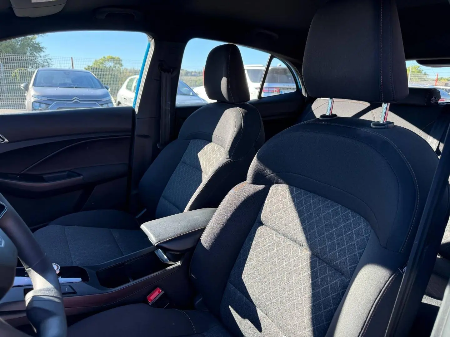 Vue intérieure côté droit montrant les sièges avant en tissu noir avec accoudoir central dans une MG3 Como Blue 2024.