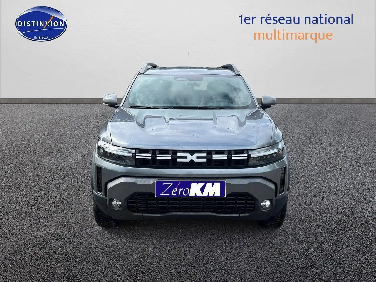 Vue avant du Dacia Duster 2025 gris schiste avec calandre distinctive et phares LED fins allumés.