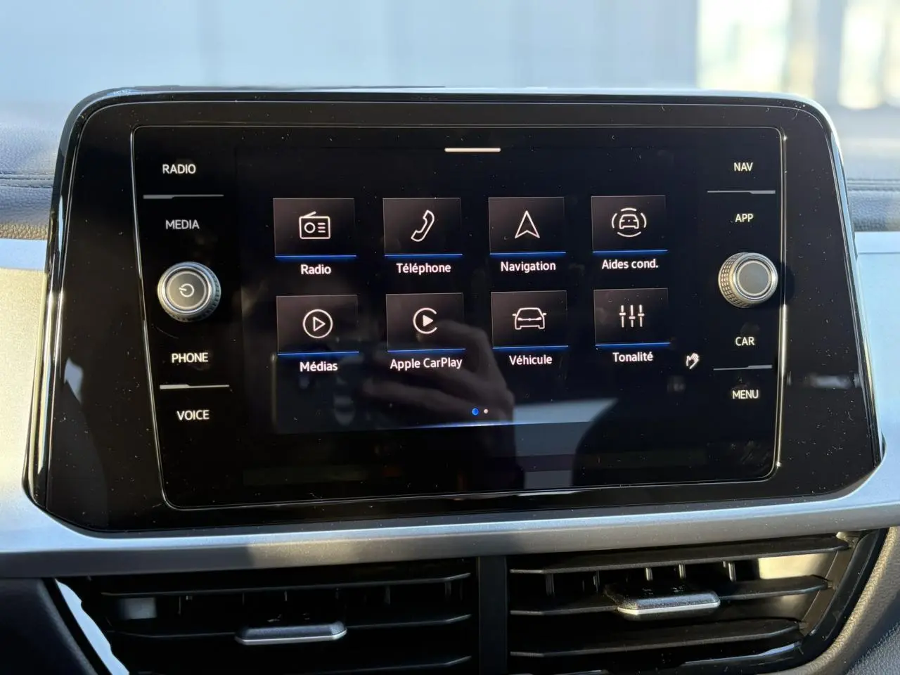 Écran tactile 8 pouces du Volkswagen T-Roc 2025 affichant les menus radio, téléphone, navigation et aides conducteur.