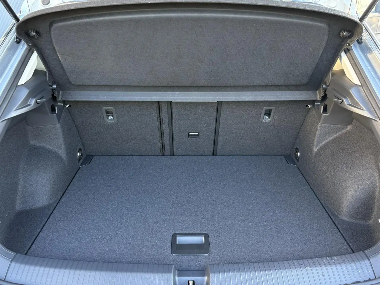 Coffre ouvert vu de l'arrière du Volkswagen T-Roc argent Pyrite, montrant un espace de chargement propre et spacieux.