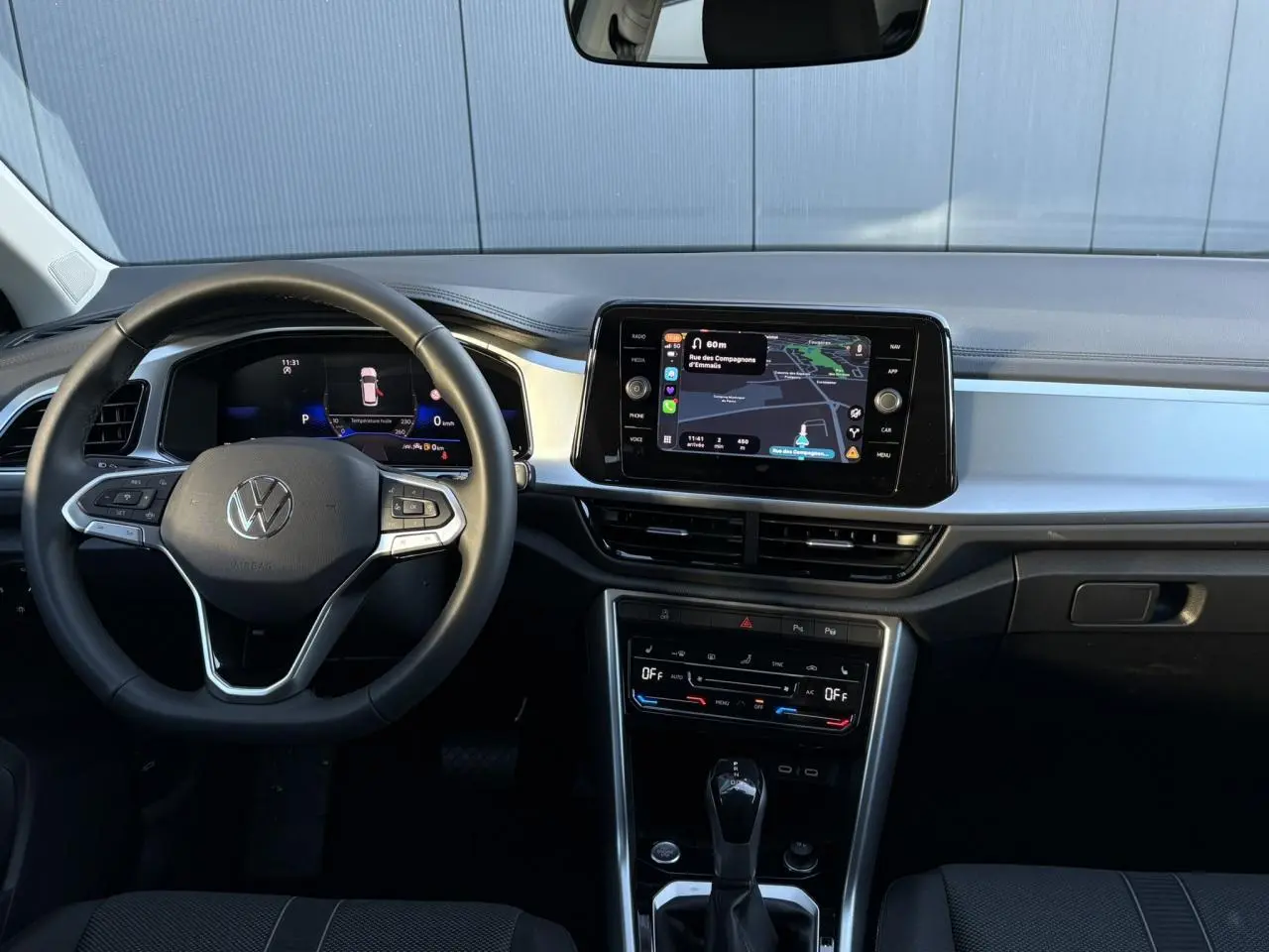 Vue frontale de l’intérieur du Volkswagen T-Roc 1.5 TSI 150 DSG Life 30 Years avec tableau de bord digital et écran tactile.