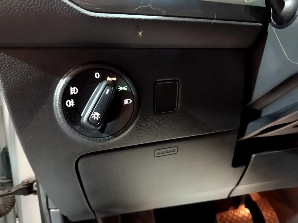 Gros plan sur le bouton de commande des phares dans l’habitacle noir d’un SEAT Ateca gris clair 2022.