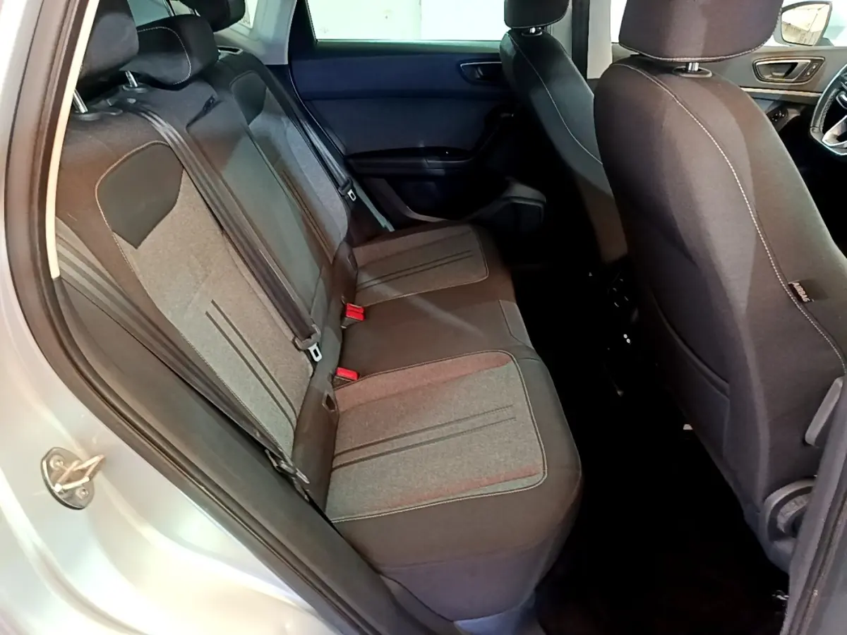 Vue intérieure côté gauche des sièges arrière gris foncé du SEAT Ateca 2022, avec ouverture de porte et partie avant visible.