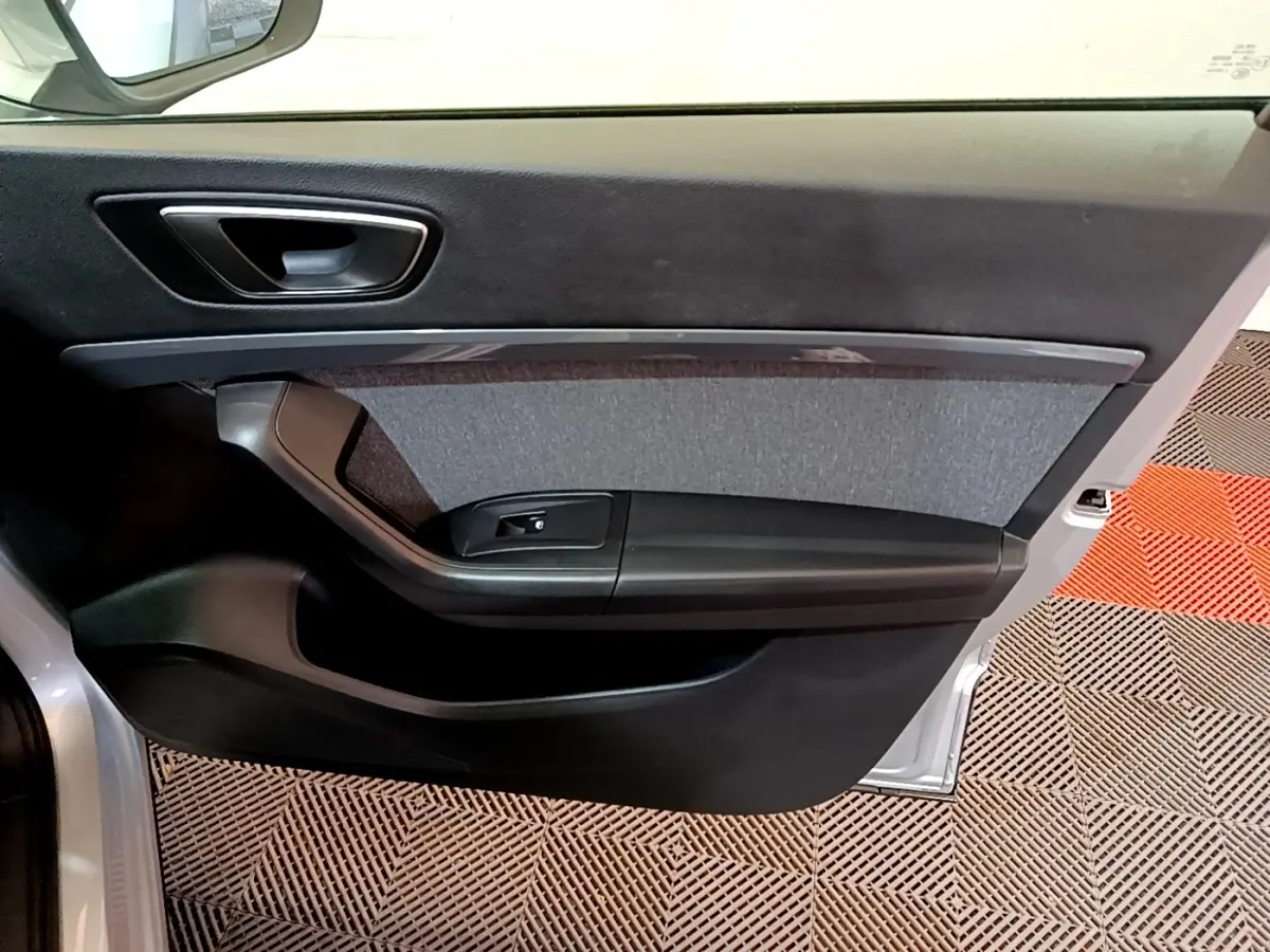 Vue intérieure de la porte avant gauche grise du SEAT Ateca 2022 avec garniture tissu et commande de vitre noire.