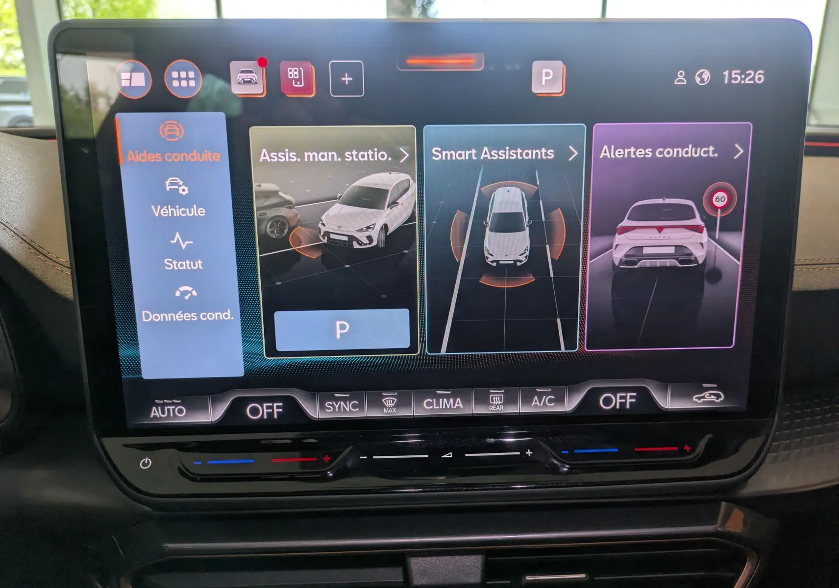 Écran tactile du tableau de bord de la CUPRA Leon noir 2025 montrant les aides à la conduite et alertes.