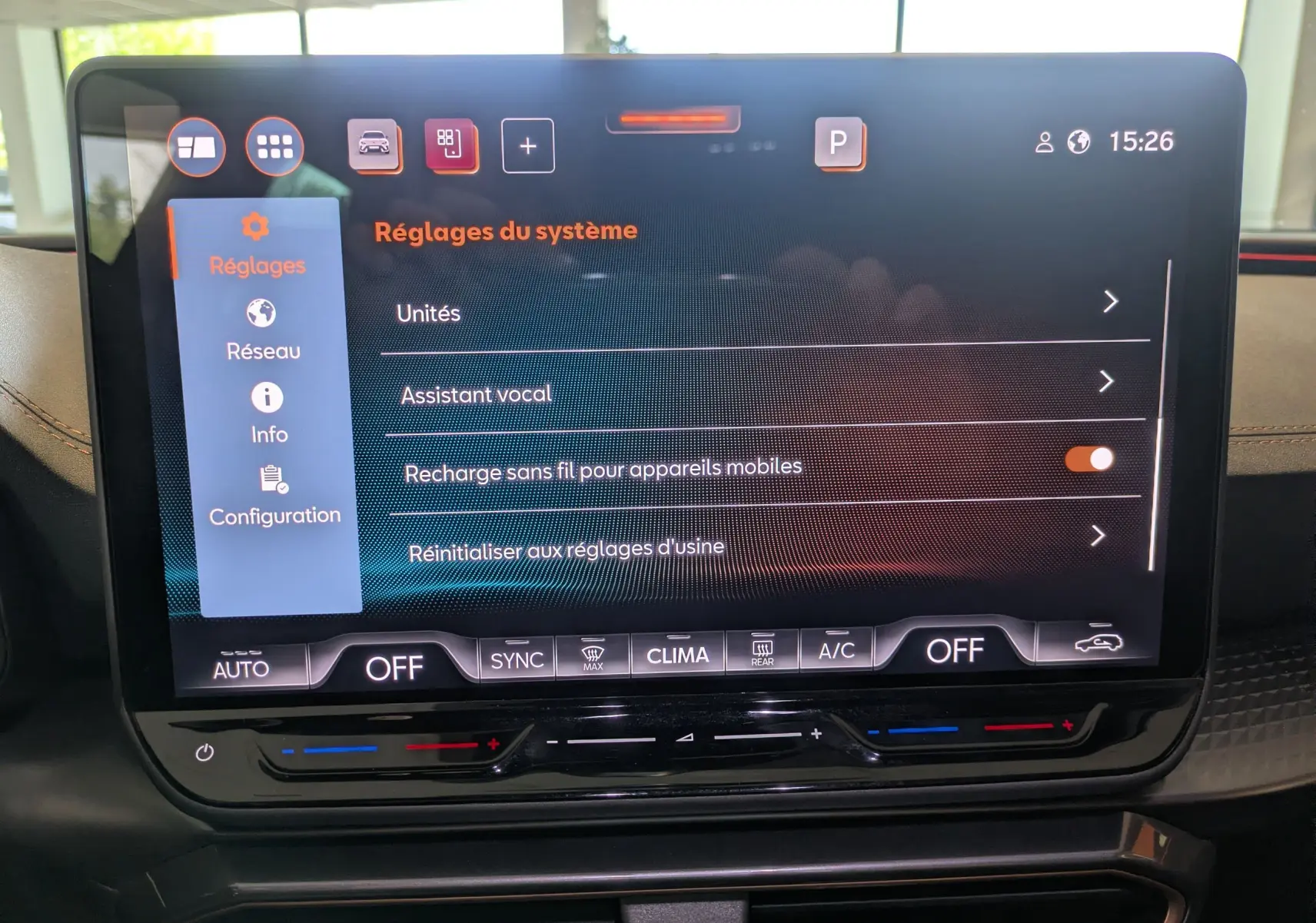 Écran tactile central du tableau de bord de la CUPRA Leon 2025 affichant les réglages système, avec commandes climatisation en dessous.