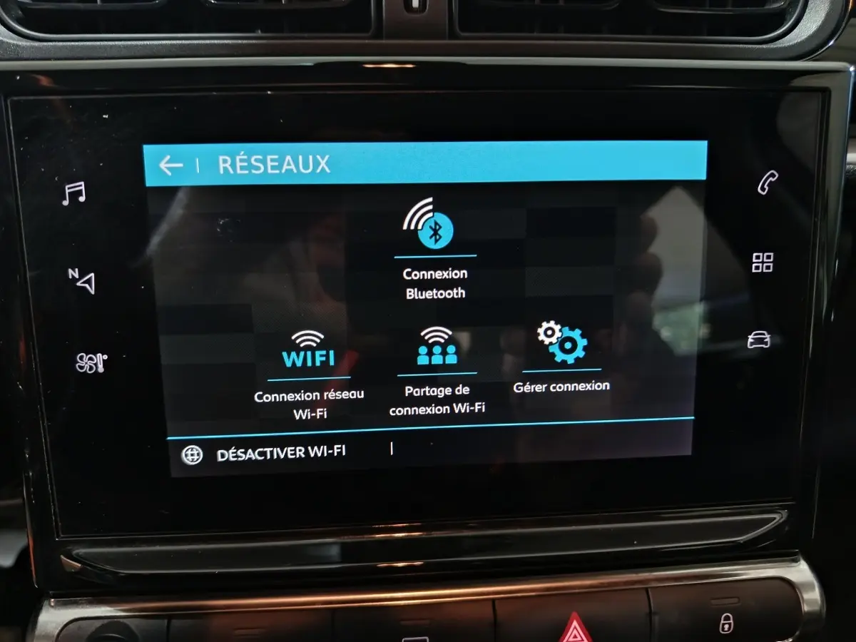 Écran tactile central de la Citroën C3 2024 affichant les options de connexion Wi-Fi et Bluetooth, intérieur noir.