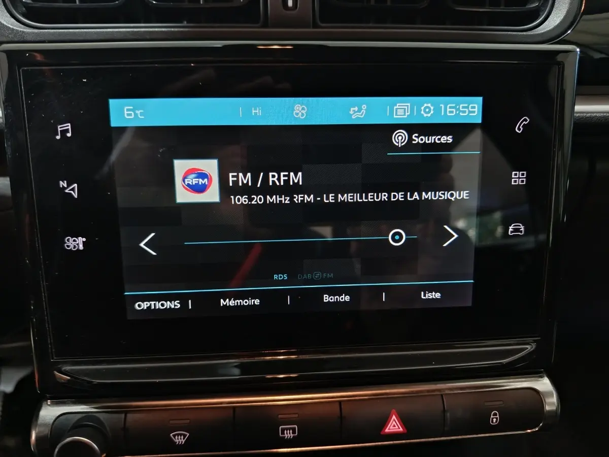 Écran tactile central de la Citroën C3 BlueHDi 100 BVM PLUS 2024 affichant la radio FM, intérieur noir.