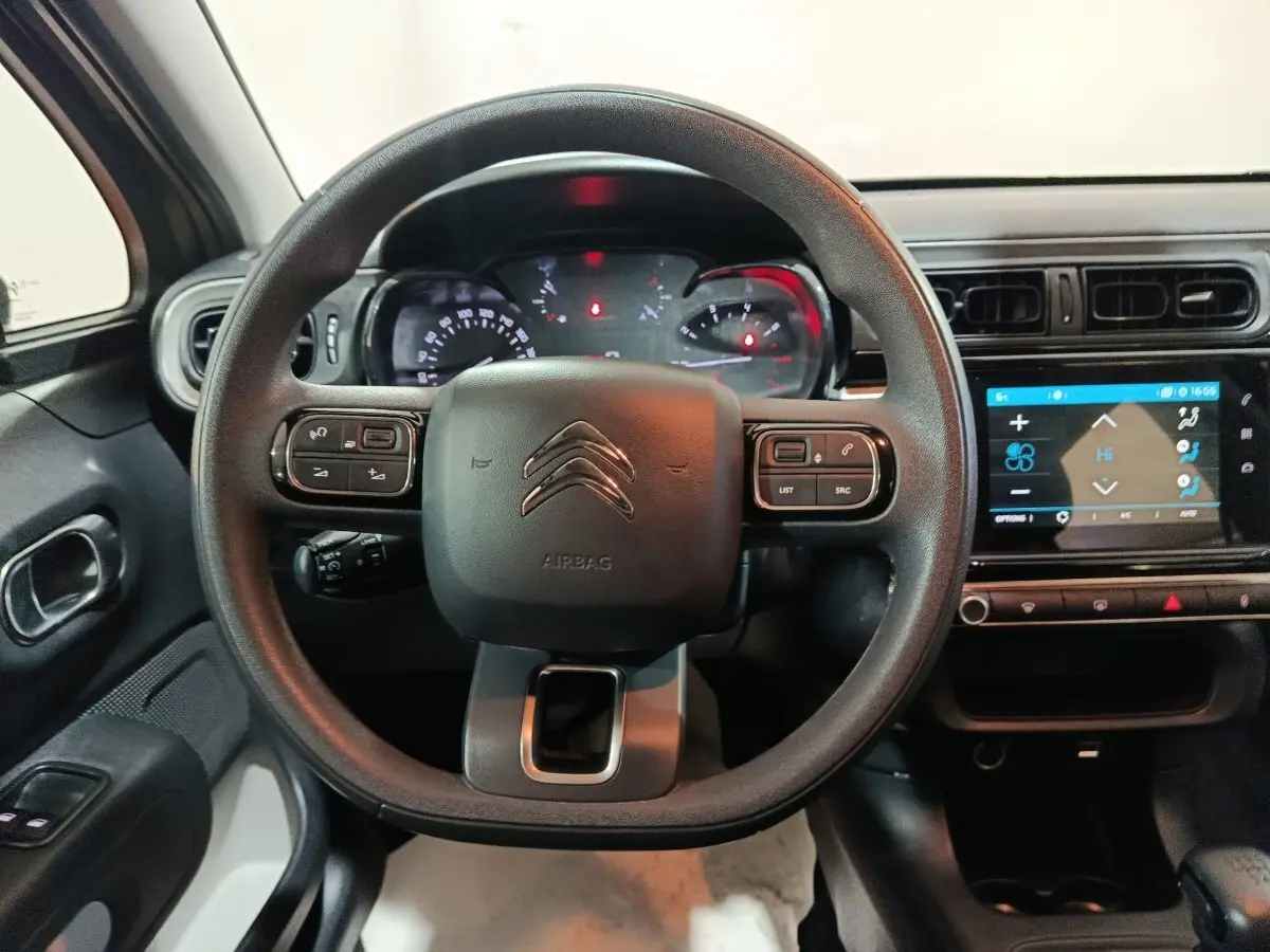 Vue intérieure centrée sur le volant multifonctions noir d'une Citroën C3 2024 avec tableau de bord et écran tactile.