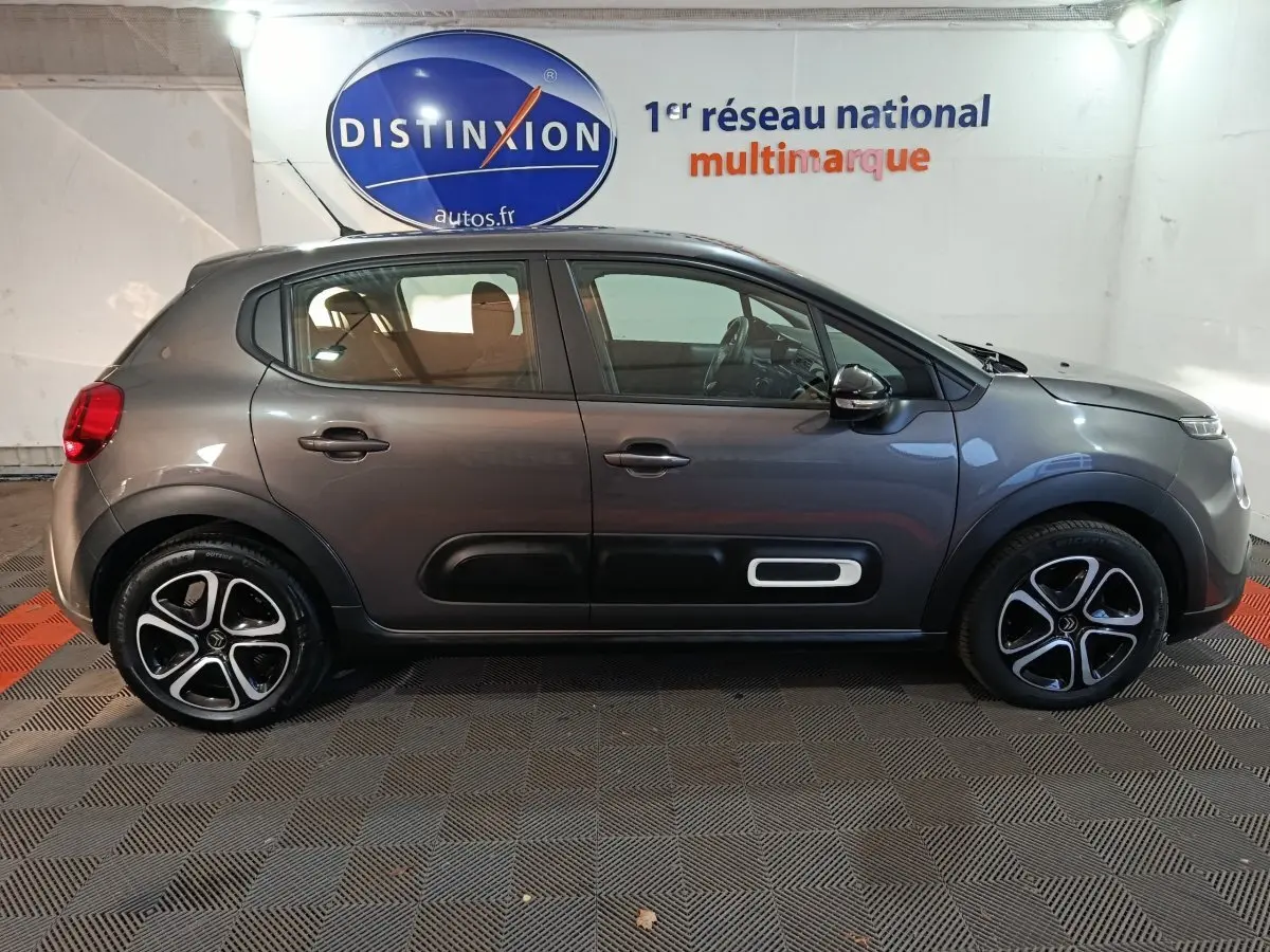 Profil droit d'une Citroën C3 2024 gris foncé avec protections latérales noires et jantes bi-ton.