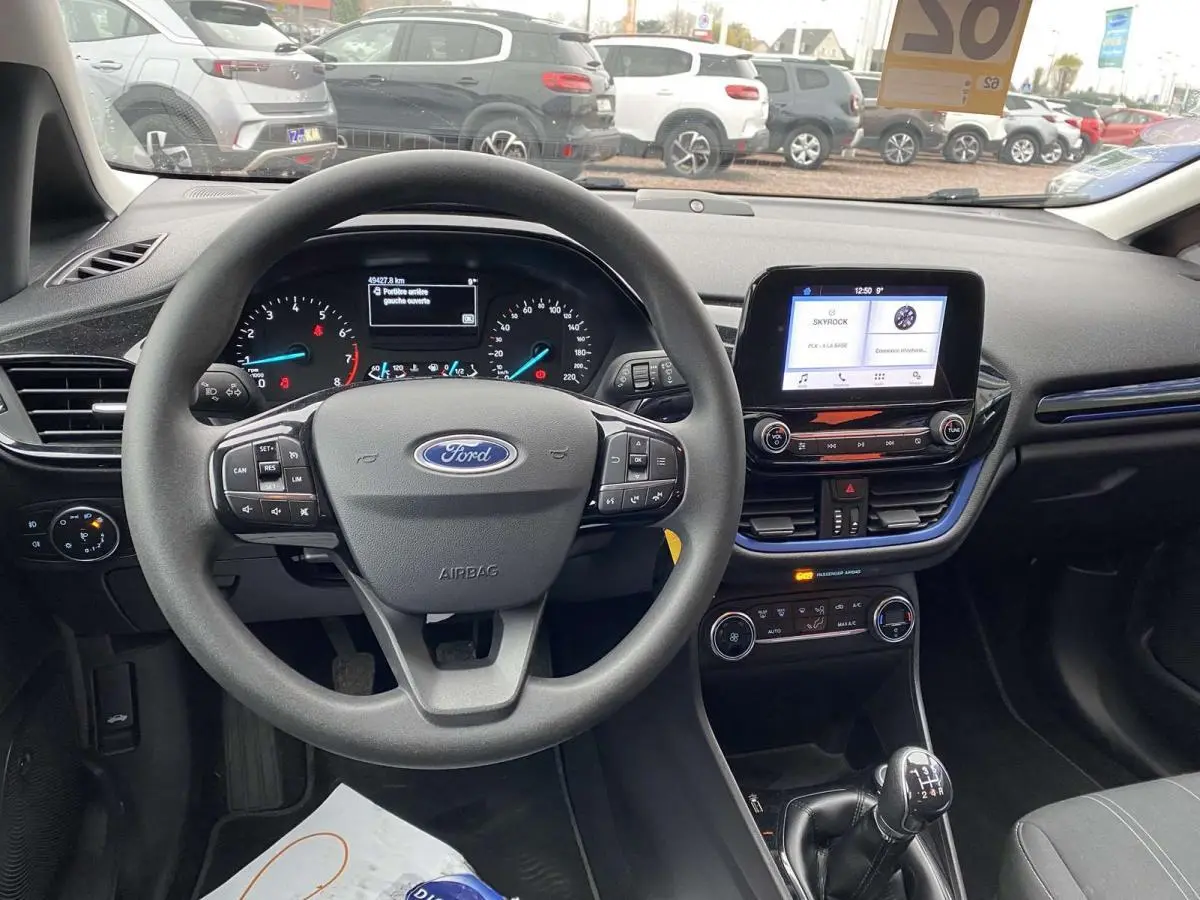 Vue intérieure avant de la Ford Fiesta bleu foncé 2017, volant multifonction et levier de vitesse manuel visible.